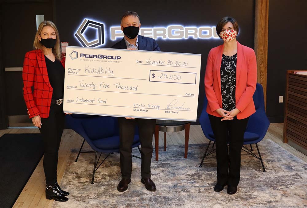 PEER CEO holding a cheque of $25,000 to donate to KidsAbility