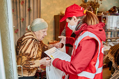 Canadian Red Cross helping an old lady in Ukraine