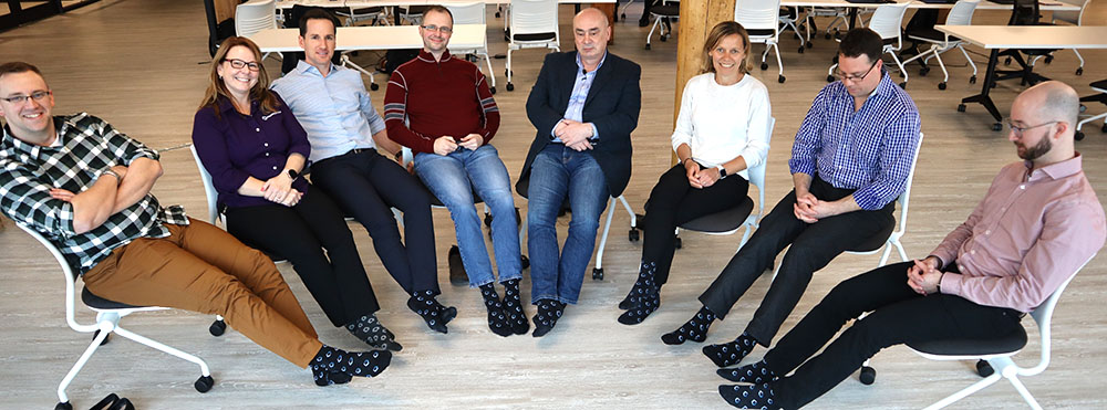 People sitting with PEER Group-branded socks on