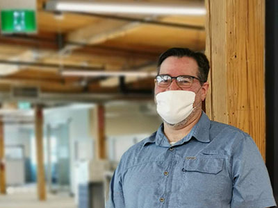 Man smiling with a mask on in the office